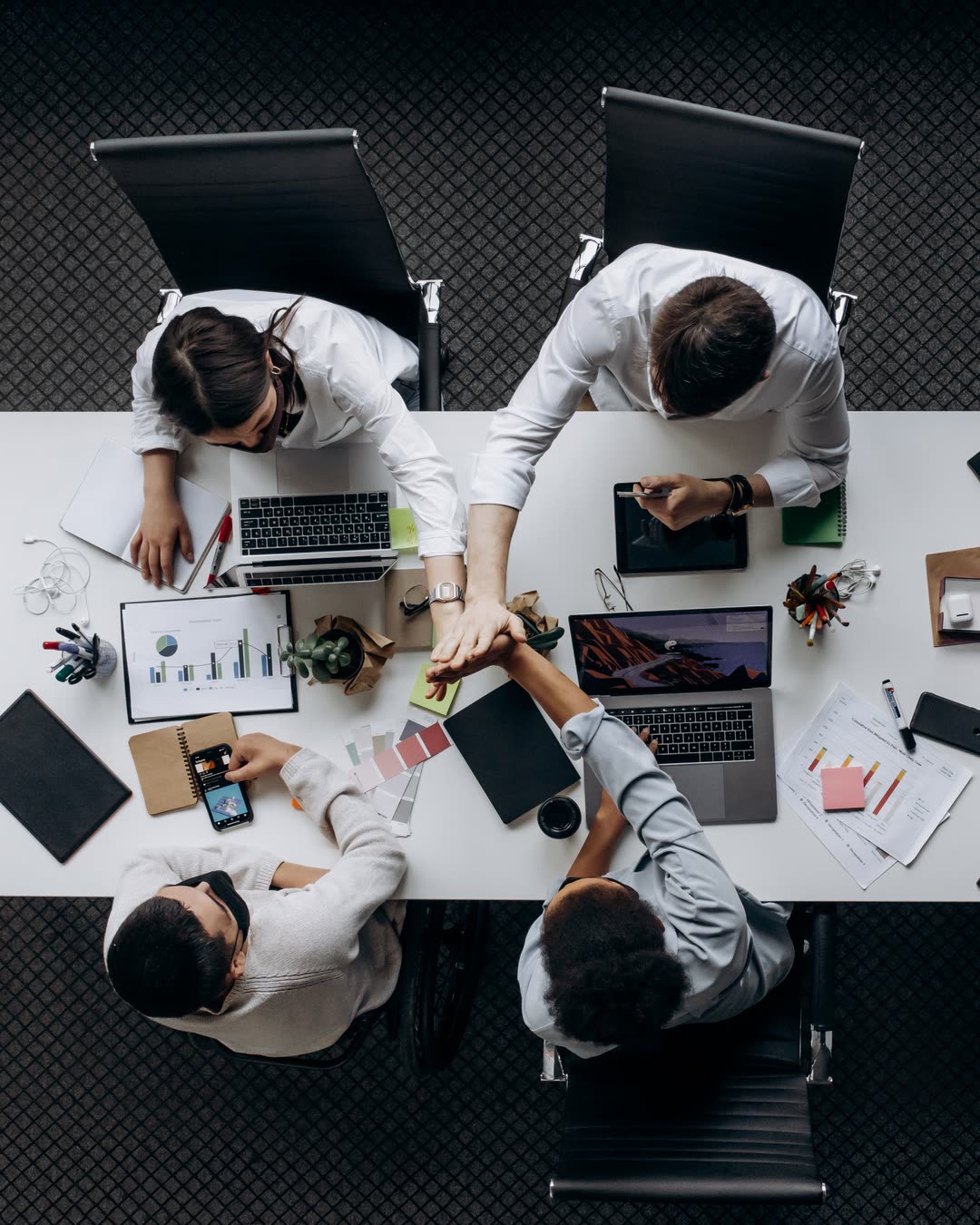 A founding team working around one table, hands in